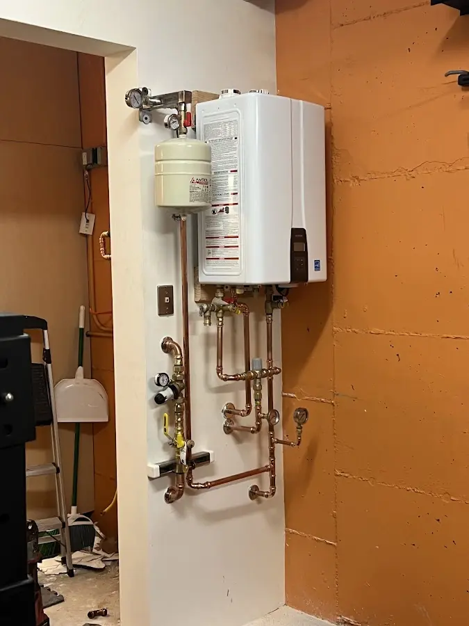 Plumbing technician inspecting water heater connections in Hurley